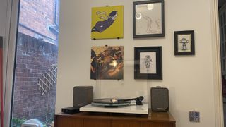 Vinyl display on wall with phono frames above turntable system