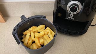 Magic Bullet Air Fryer next to tray of uncooked chips