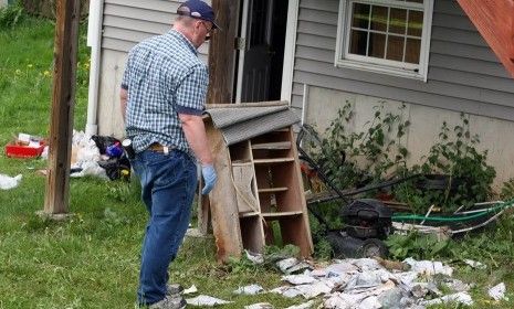 An investigator sorts through the left behind belongings of Shazad.