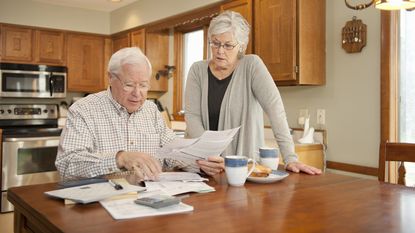 An older couple goes over finances at the kitchen table.
