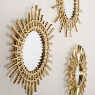 Brass star mirrors on wall from side angle 