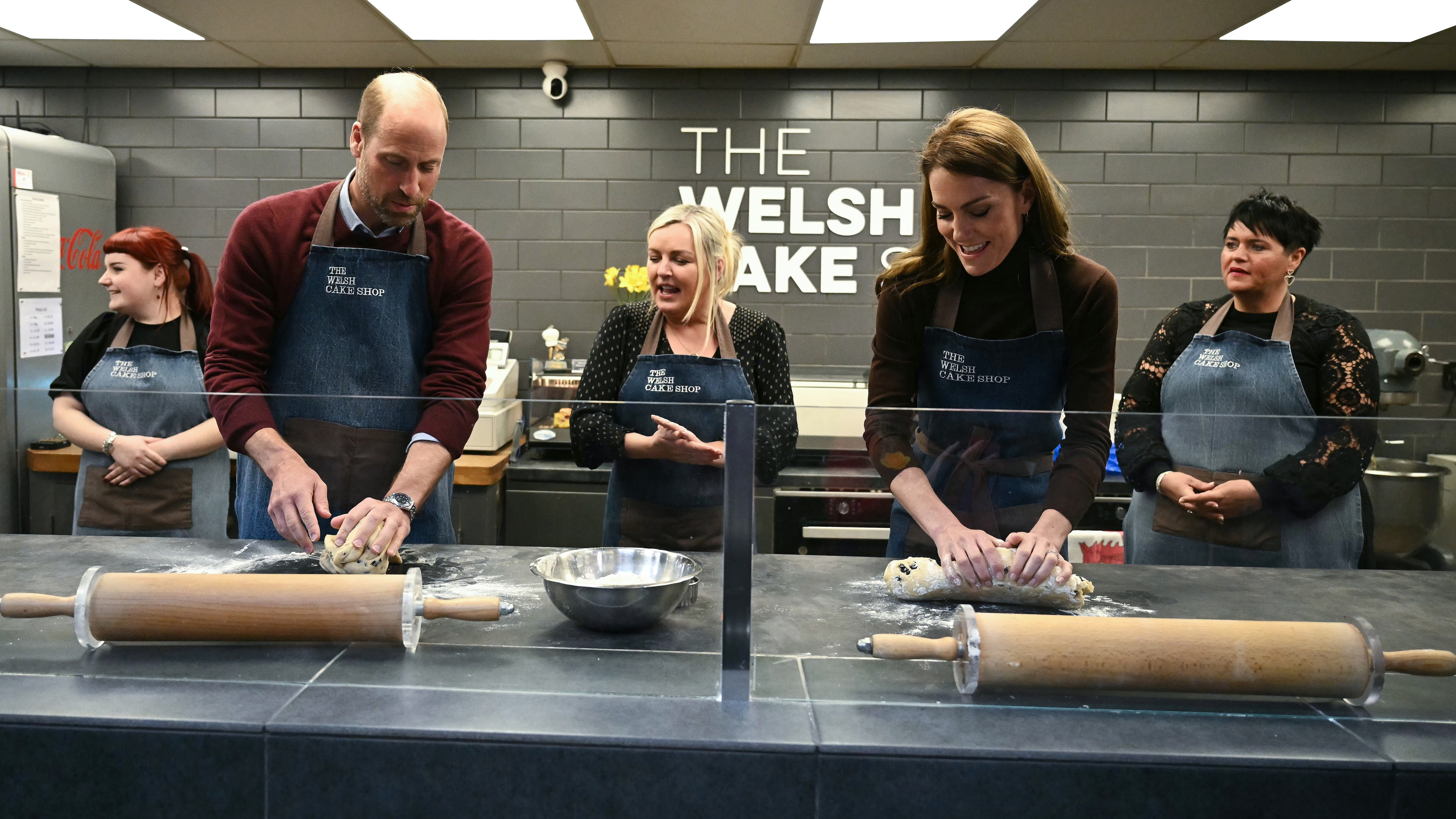Catherine, Princess of Wales and Prince William, Prince of Wales react as they make Welsh Cakes, watched by Theresa Connor, owner of the The Welsh Cake Shop during a visit to Pontypridd Market on February 26, 2025