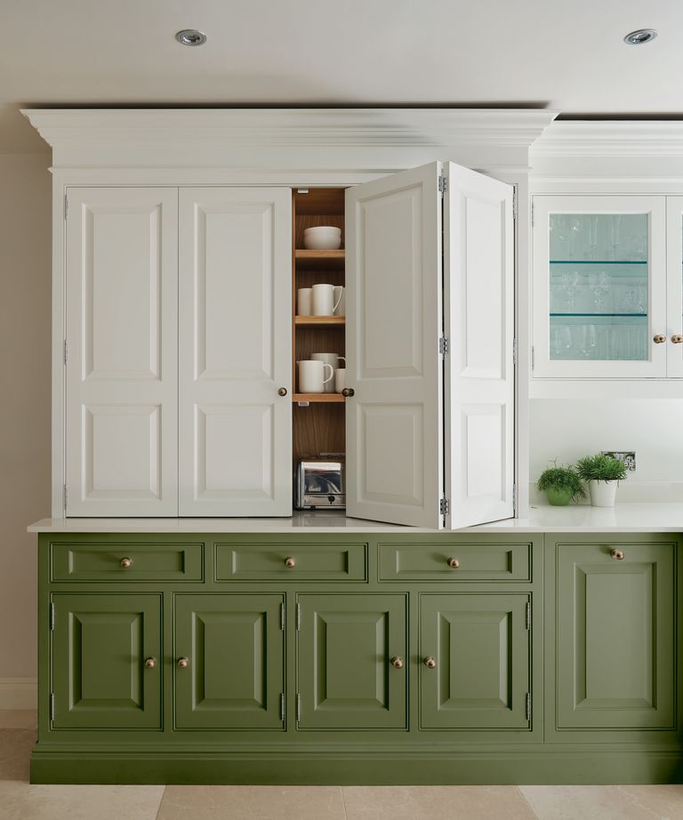 Green and white colour block kitchen with cupboard with folding doors