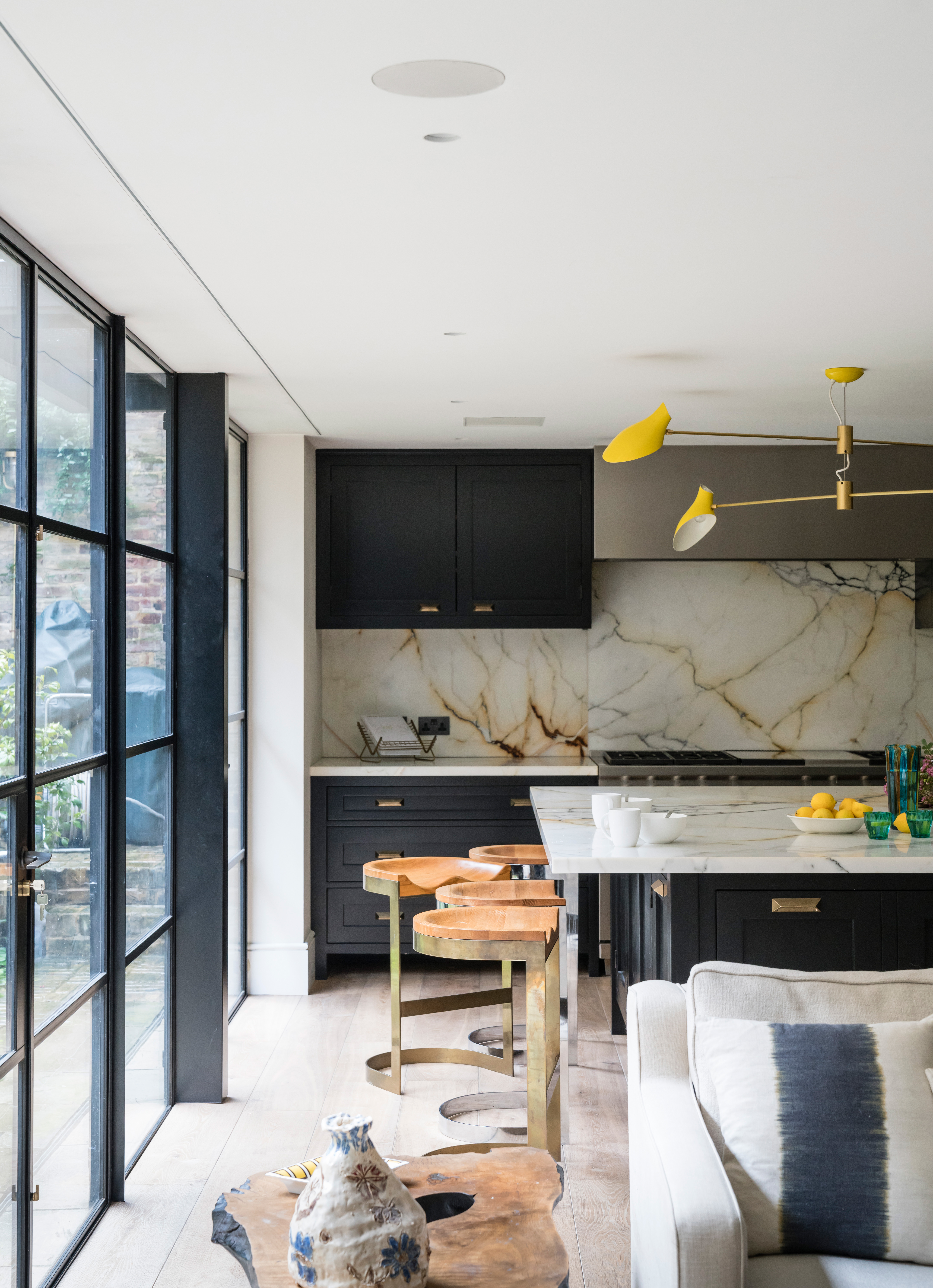 Dark blue open plan kitchen with marble slab splashback