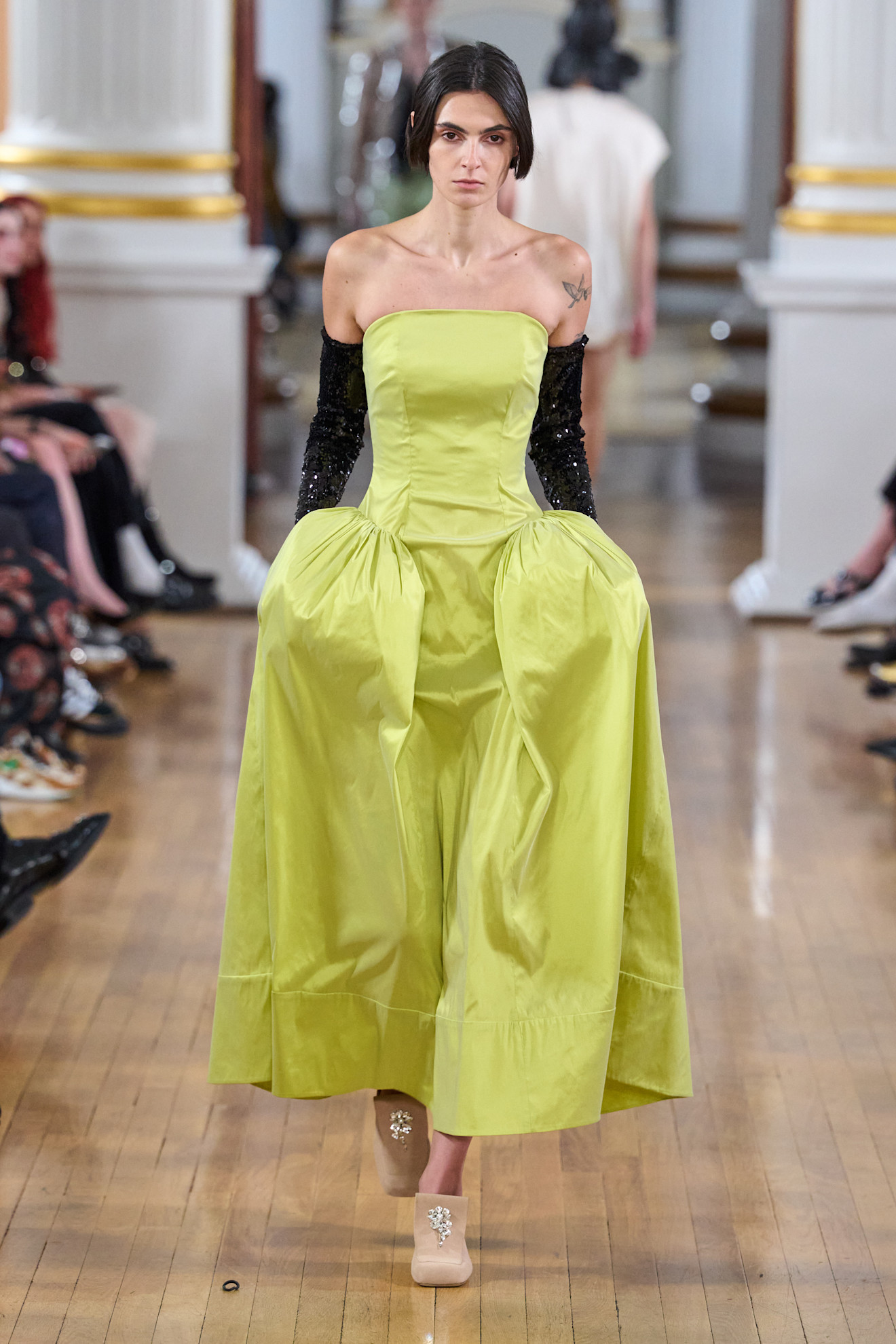 Simone Rocha model a strapless slime green gown styled with sparkly black opera gloves and nude mules.