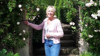 Carol Klein standing by an arch of roses in Gardeners' World