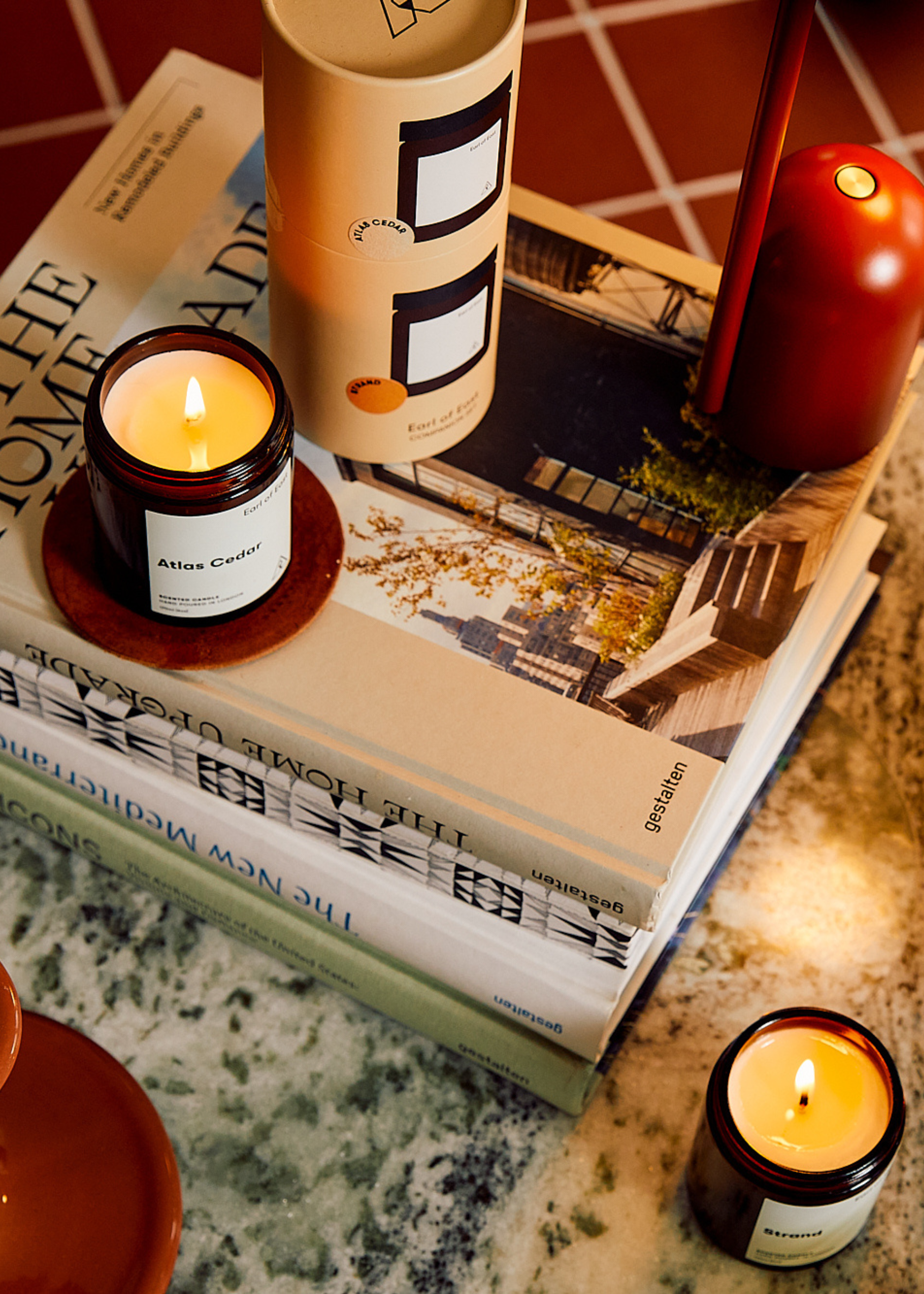 A set of candles on a coffee table book stack on a marble table