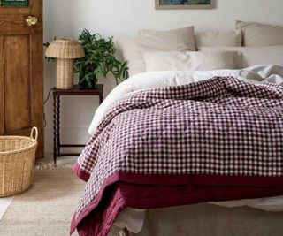 A gingham throw against white bedding.