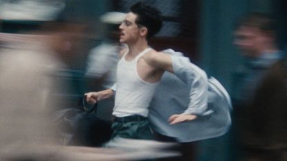 Timothee Chalamet runs down a busy street