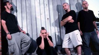 System Of A Down standing in front of some shuttered doors