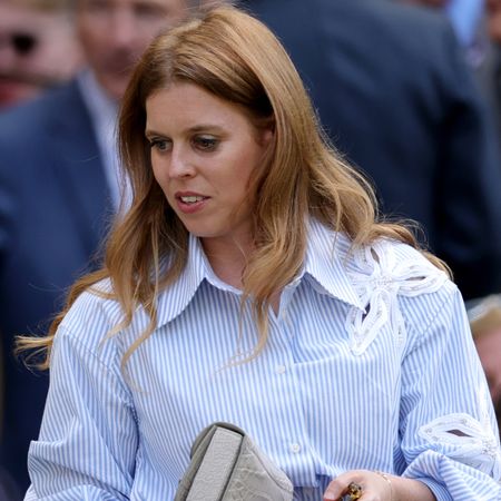 Princess Beatrice wearing a striped shirt holding a clutch
