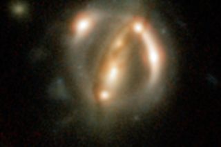 The distant quasar B1608+656 is smeared into bright arcs by two closer galaxies in the foreground. Researchers have used two ancient quasars, which emitted their light billions of years ago, to provide evidence for quantum entanglement.