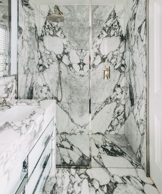 walk in shower room with veined marble shower