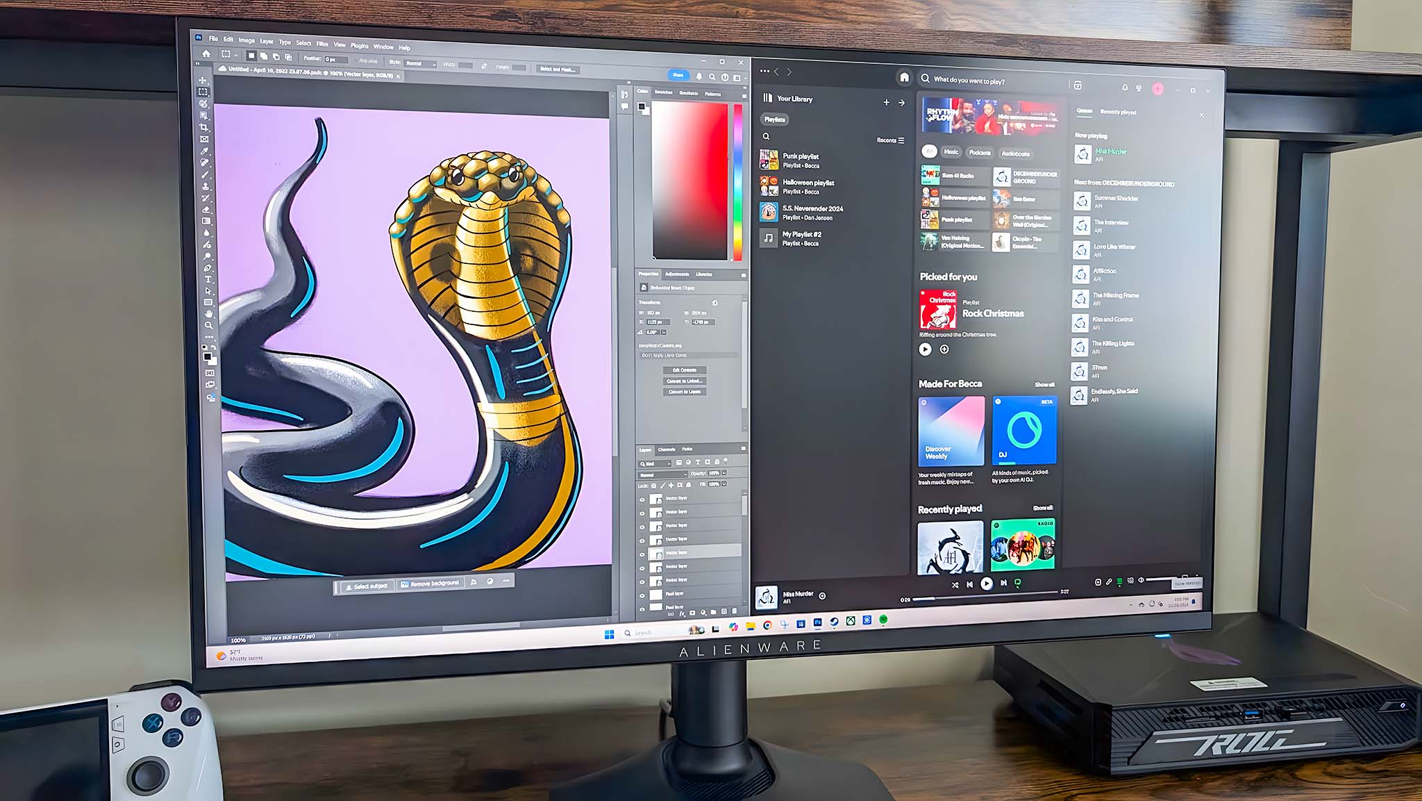 Alienware AW2725QF Gaming Monitor multitasking between programs with a split screen. Left side shows Photoshop, right side shows Spotify.