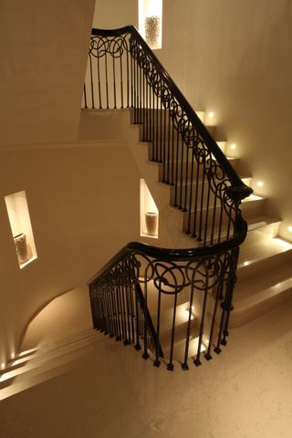 Grand staircase with ornate spindles and lighting for steps and niches