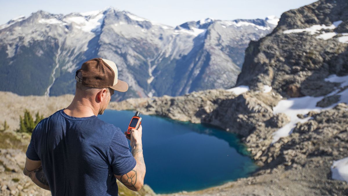 what is a satellite communicator: man holding GPS unit