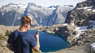 what is a satellite communicator: man holding GPS unit