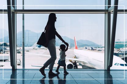 Mother and child at airport looking at planes out of the window