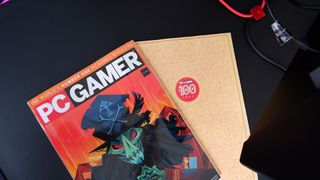 An issue of PC Gamer magazine on top of the Secretlab Magnus Pro XL.