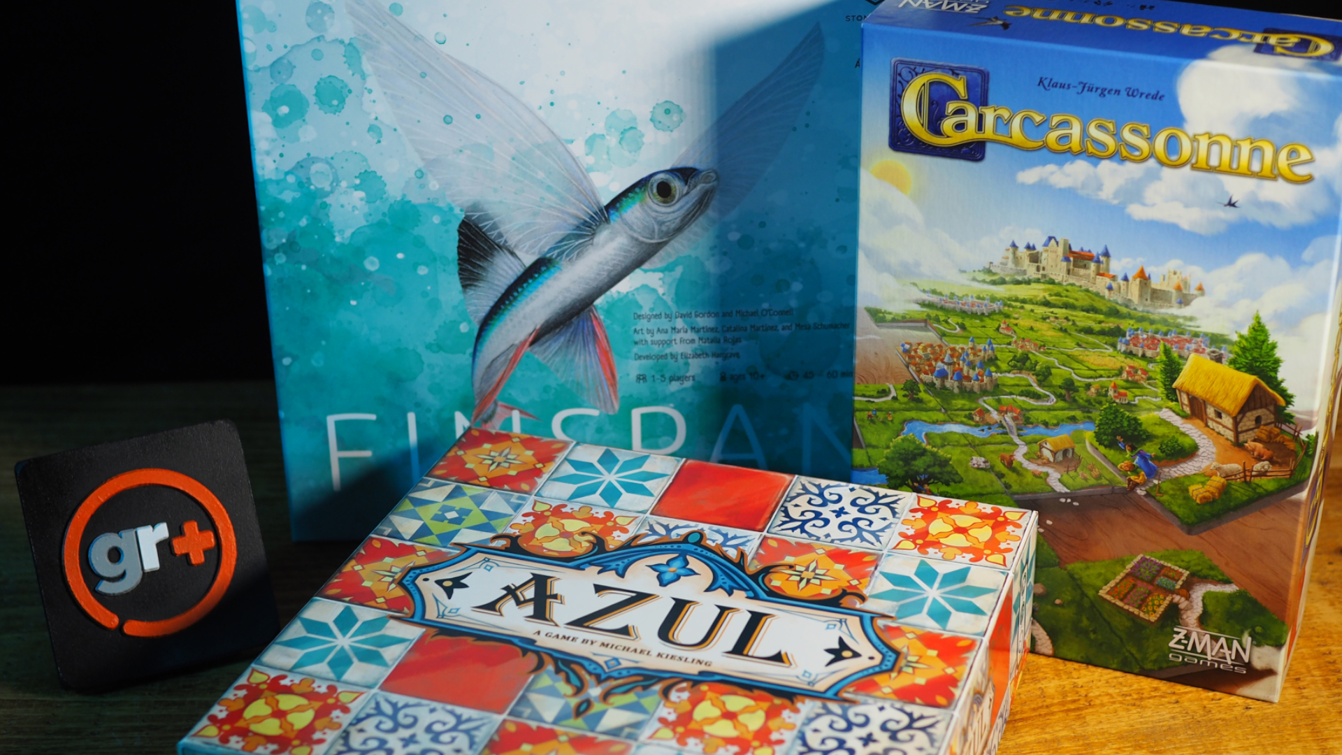 Azul, Finspan, and Carcassonne boxes on a wooden table beside a GamesRadar+ logo