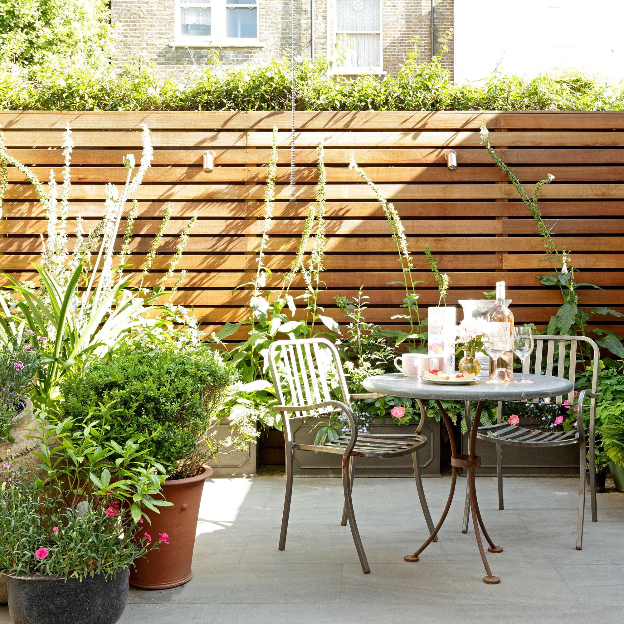 patio area with bistro set and pot plants