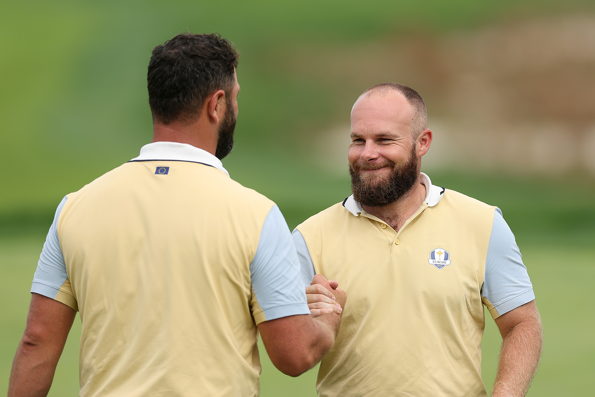 Jon Rahm shaking hands with Tyrrell Hatton, who make up the first pairing for Team Europe in Friday foursomes at the Ryder Cup 2025