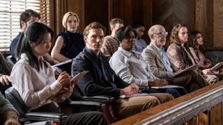 a group of jurors in a court room including one played by nicholas hoult in juror 2