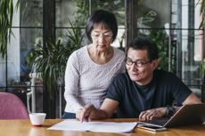 Asian mature straight couple reviewing finances
