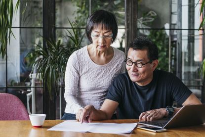 Asian mature straight couple reviewing finances