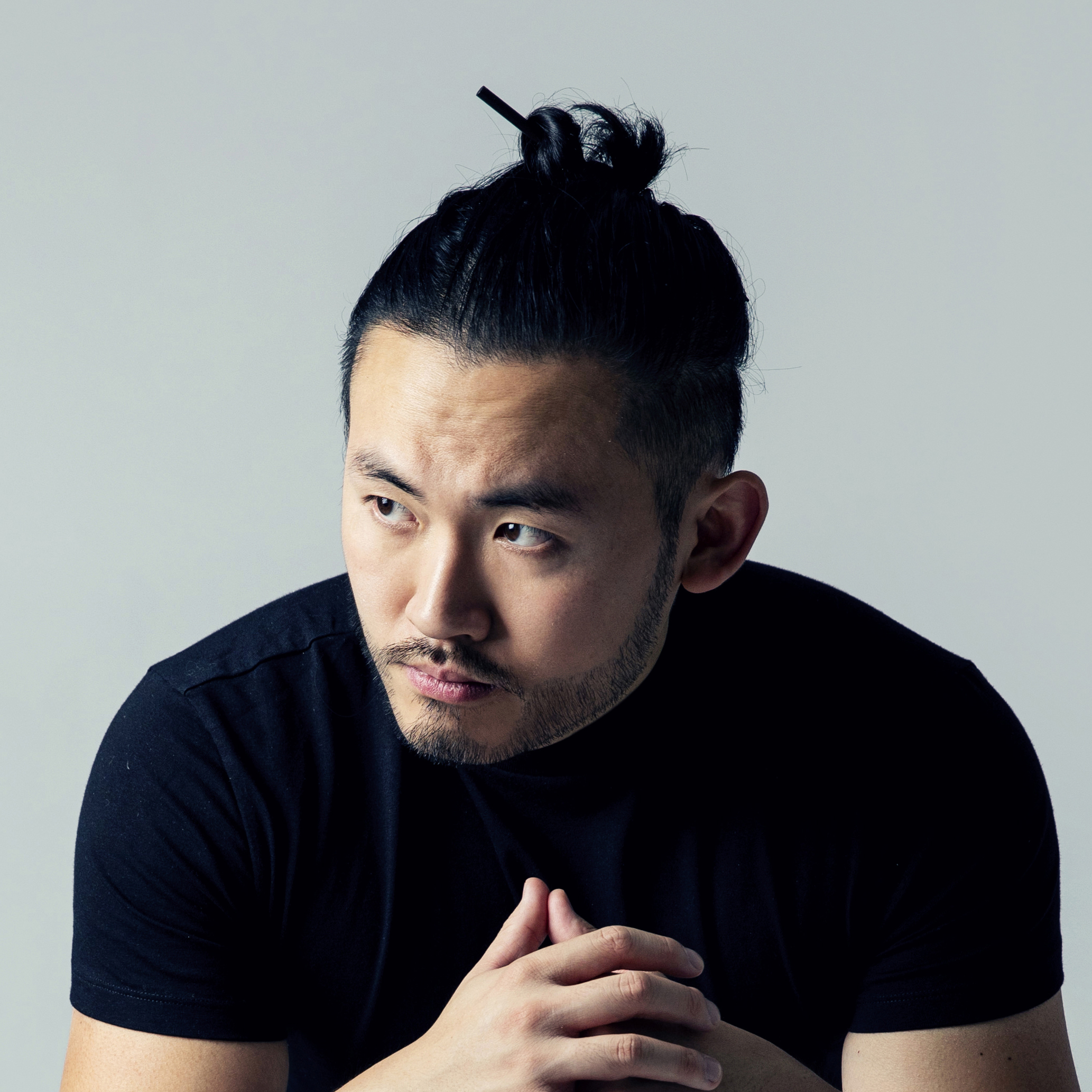 portrait of architect Tim Fu looking to the side and wearing a black t shirt