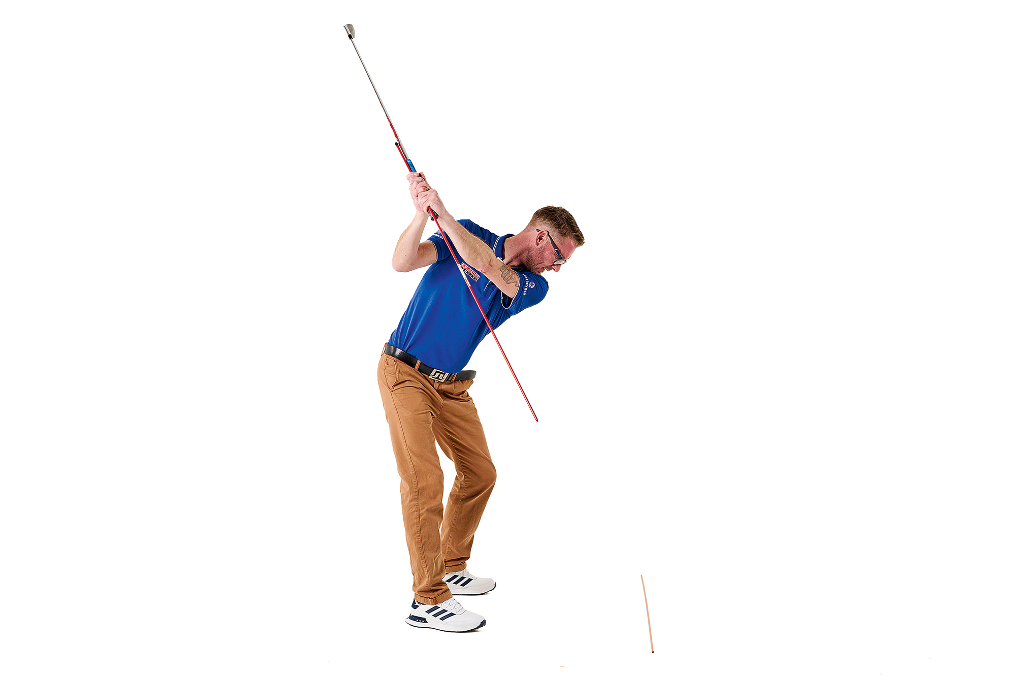 Tom Motley demonstrating the golf swing plane mirror drill, with the club at the top of the backswing and the alignment stick pointing down towards the floor