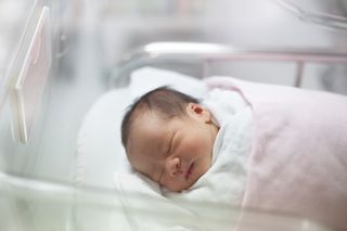 A newborn baby girl in a delivery room.
