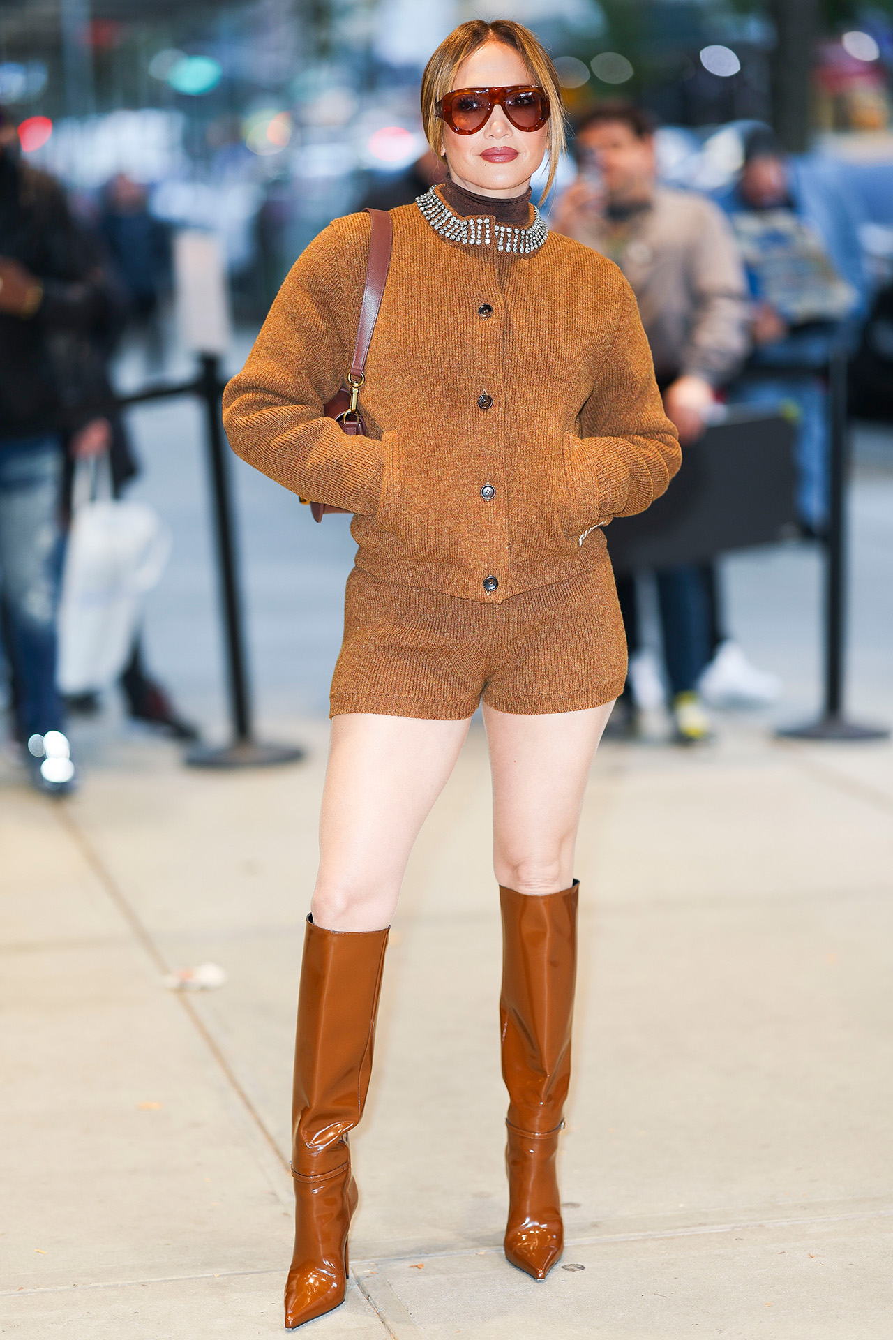 Jennifer Lopez in camel knit suit and brown boots for Unstoppable premiere 2024.