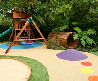 backyard playground area with slide, climbing frame and timber tube