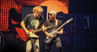 Sammy Hagar riffs on a red Gibson Explorer as Joe Satriani solos on his Chrome Boy Ibanez signature guitar as the pair perform on the Best Of All Worlds Tour 2024.