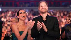 Meghan Markle and Prince Harry clapping and cheering together 