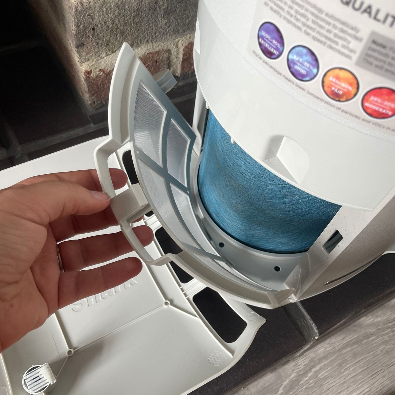 Hand pulling out dust defence guard of the Shark air purifier