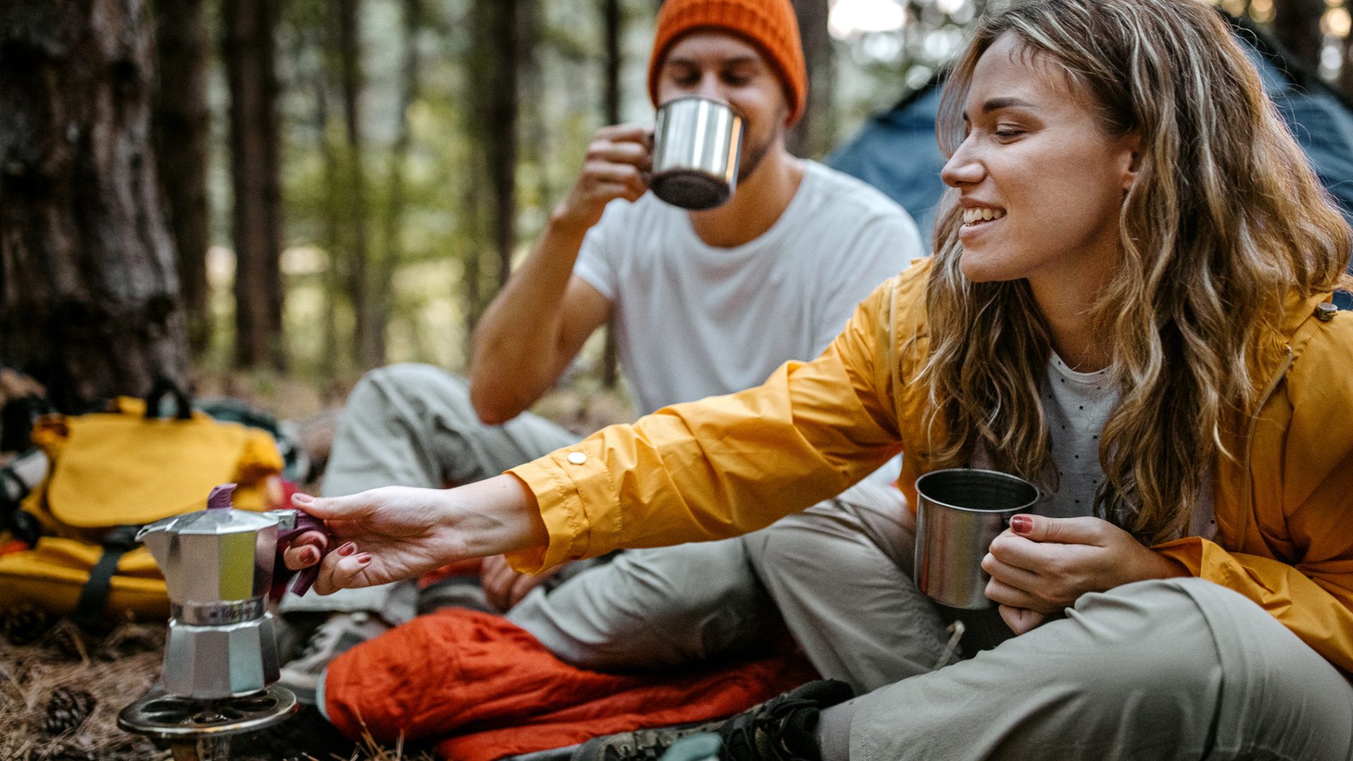 A couple camping and drinking coffee