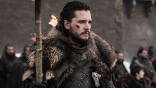 Kit Harington looking sad as Jon Snow holding a big stick in Game of Thrones.