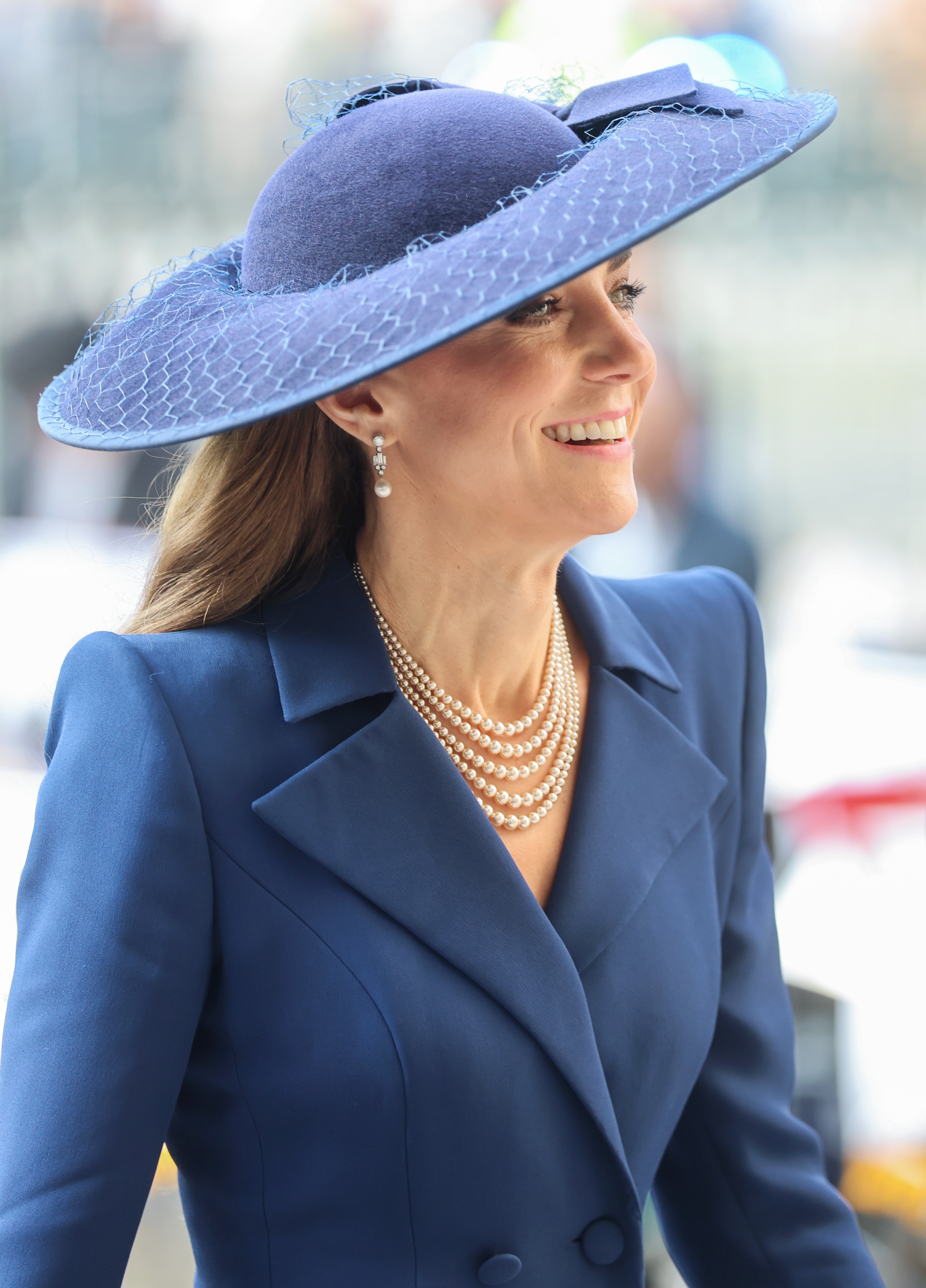 Princess Kate wearing a blue hat and coat and smiling