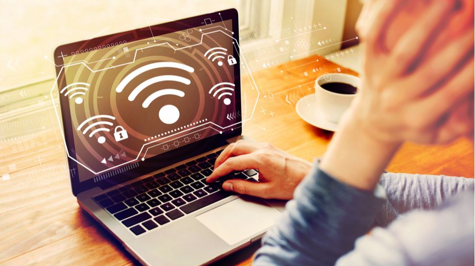 Man using laptop with wifi signal icon