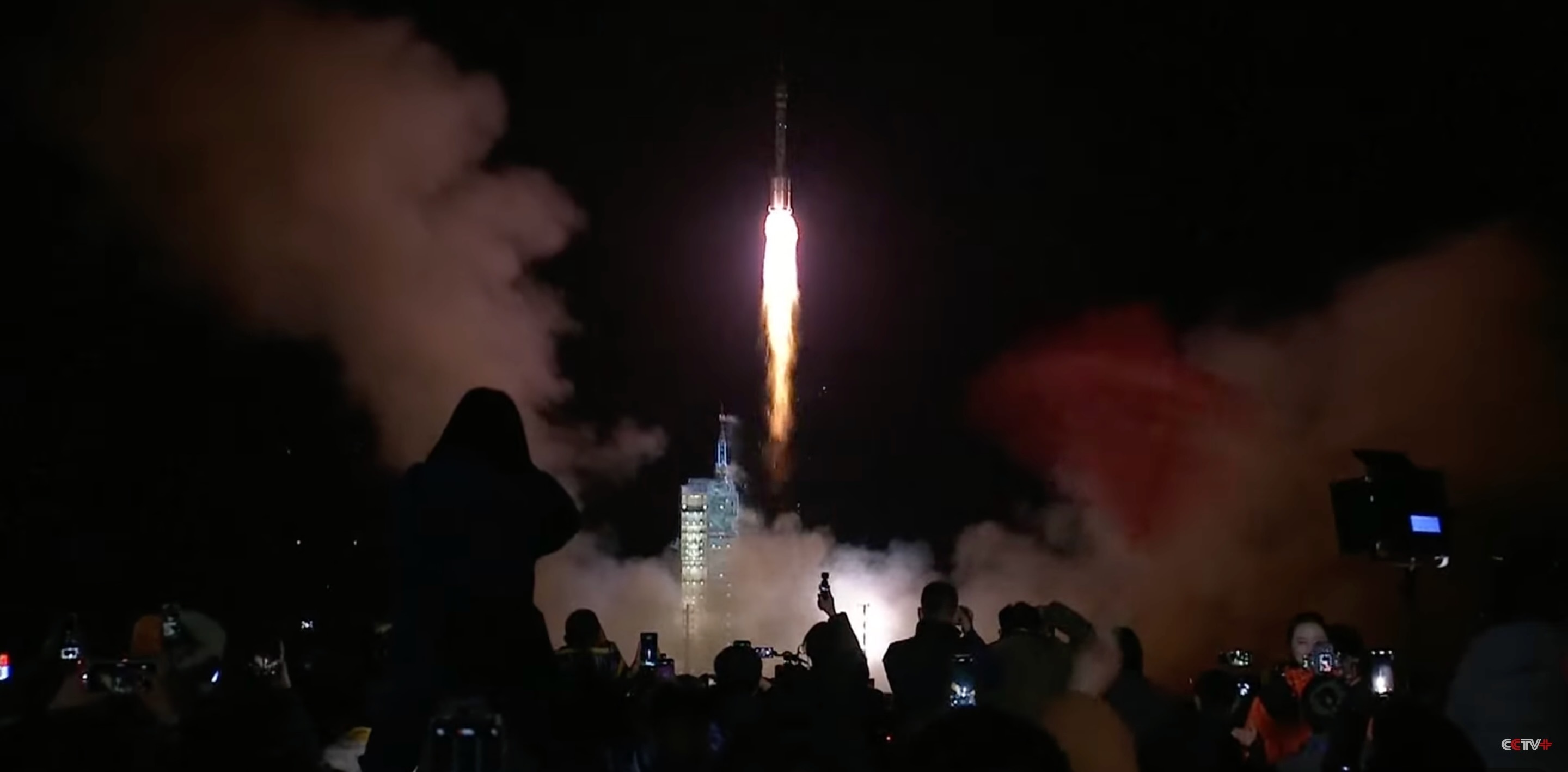a white rocket launches into a dark night sky