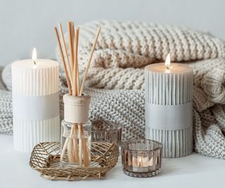 candle and diffuser with blankets in the background