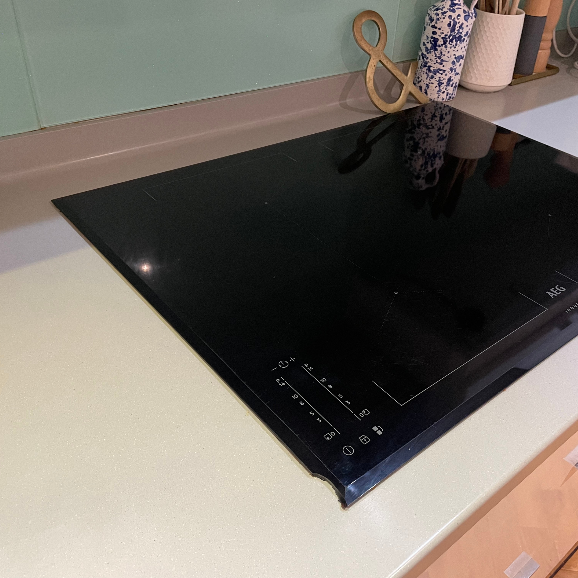 a black induction hob with chip on one side