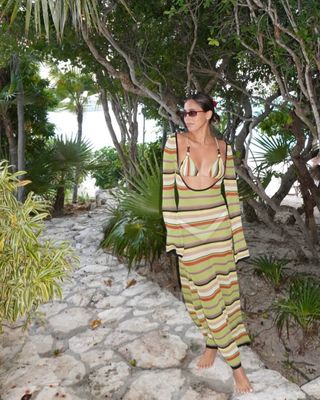 Woman wearing long striped crochet cover-up.