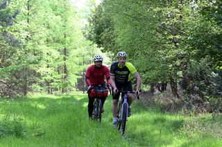 Brothers riding side by side on narrow path
