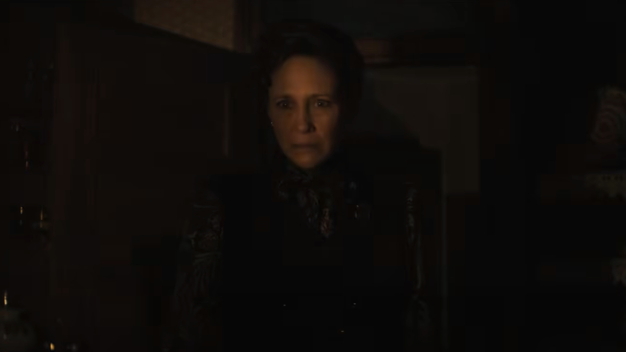 Vera Farmiga as Lorraine Warren in darkness looking scared in The Conjuring: Last Rites
