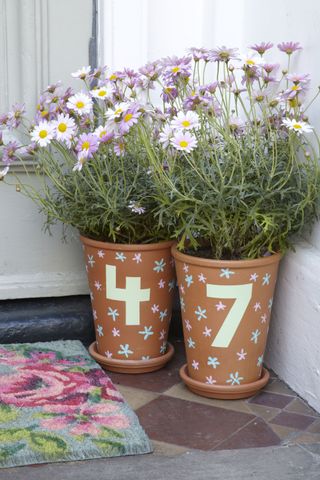 terracotta plant pots turned into a house number with door number painted on the side