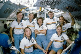 Mary Cleave poses on the aft flight deck of space shuttle Atlantis with her STS-61B crewmates: Jerry Ross, Brewster Shaw, Bryan O'Connor, Rodolfo Neri, Woody Spring and Charlie Walker.