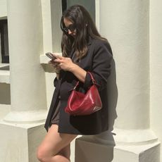 SEO Writer Ava Gilchrist carries a red Loewe Puzzle bag 